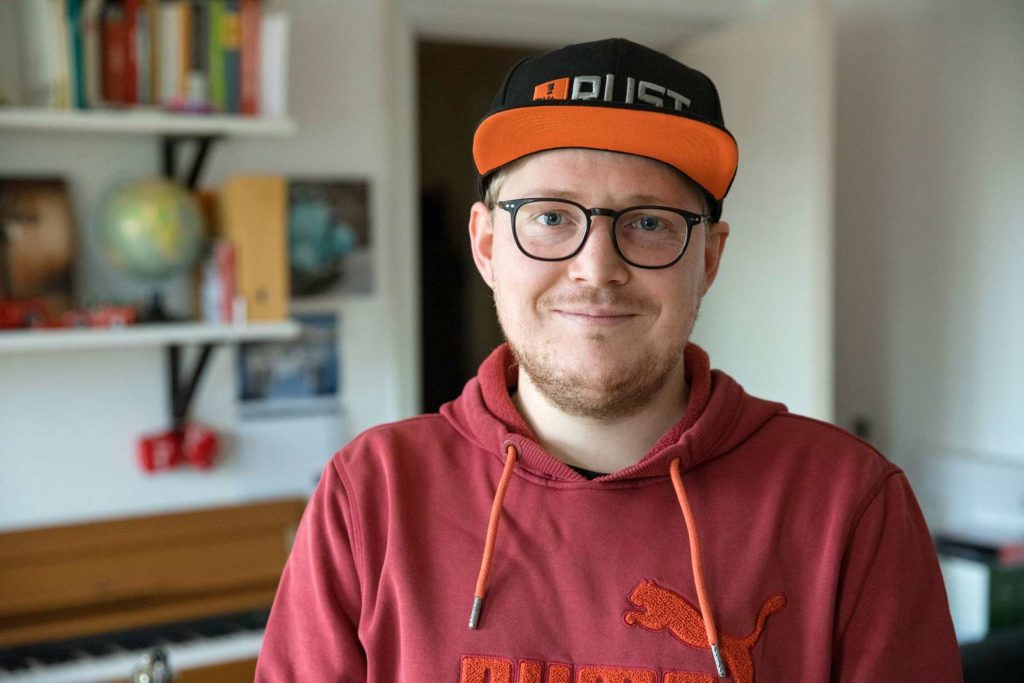 Mand med kasket smiler til kameraet