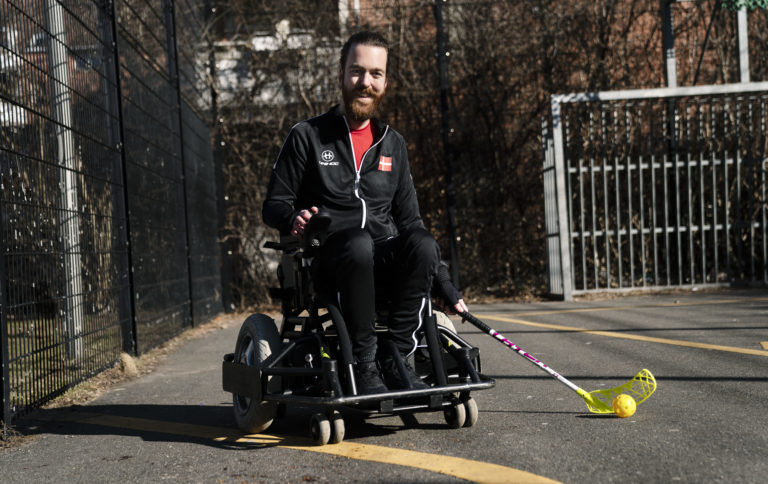 Anders i sin el-kørestol med floorball-stav i hånden