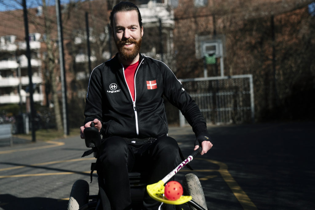 Anders med floorball-stav og i sin el-kørestol.