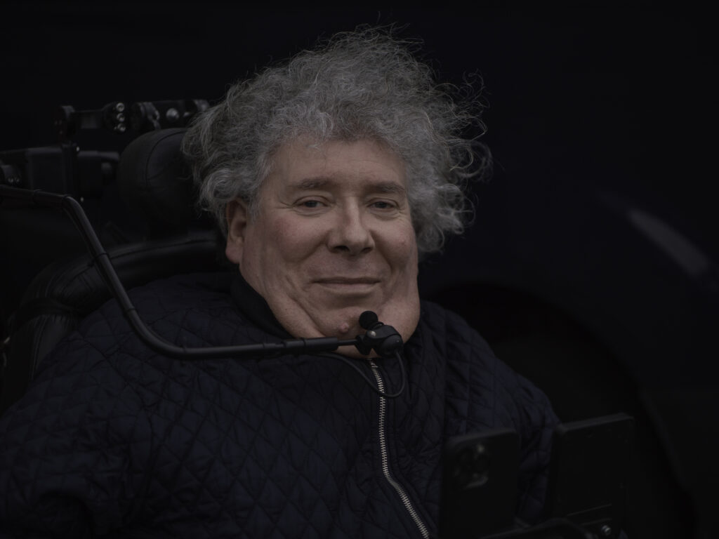 portræt af Jan V. Jakobsen, ældre mand i kørestol med respirator